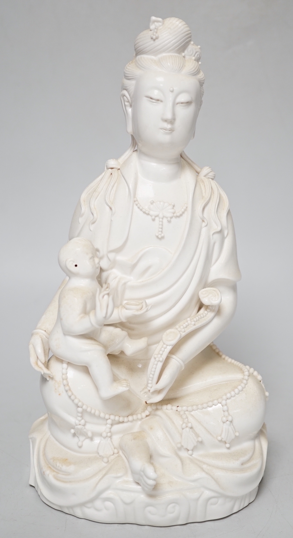 A blanc de chine figure of Guanyin and a child, 27cm